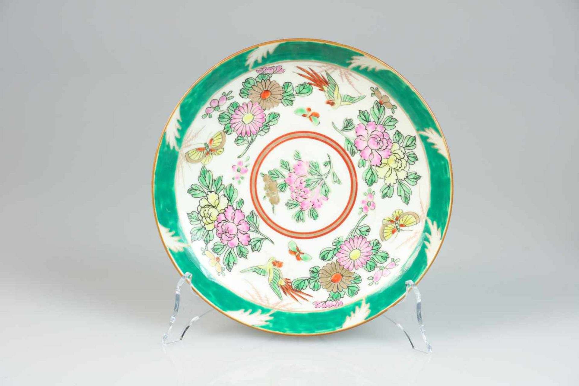 Een porseleinen bord met floraal decor. Japan, 1e helft 20e eeuw.Diam. 21,5 cm. Geschatte opbrengst: