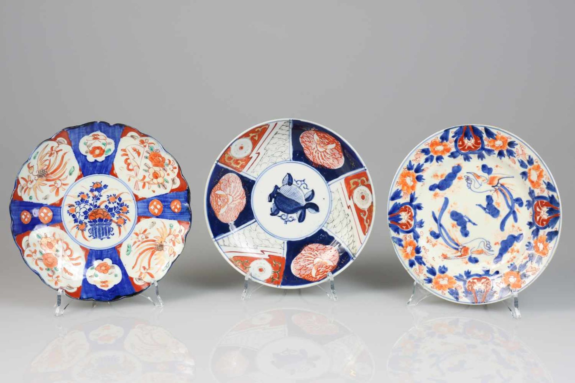 Een lot van (3) porseleinen borden met Imari decor. Japan, 19e/20e eeuw. Eén bord heeft een haarlijn