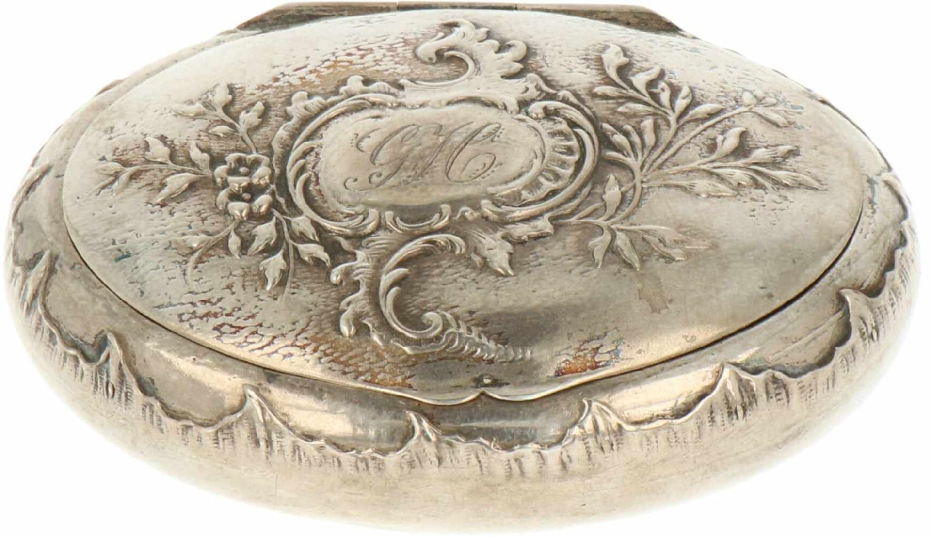 Snuifdoosje zilver.Ovaal model met ronde bodem voorzien van gedreven versieringen en cartouche met