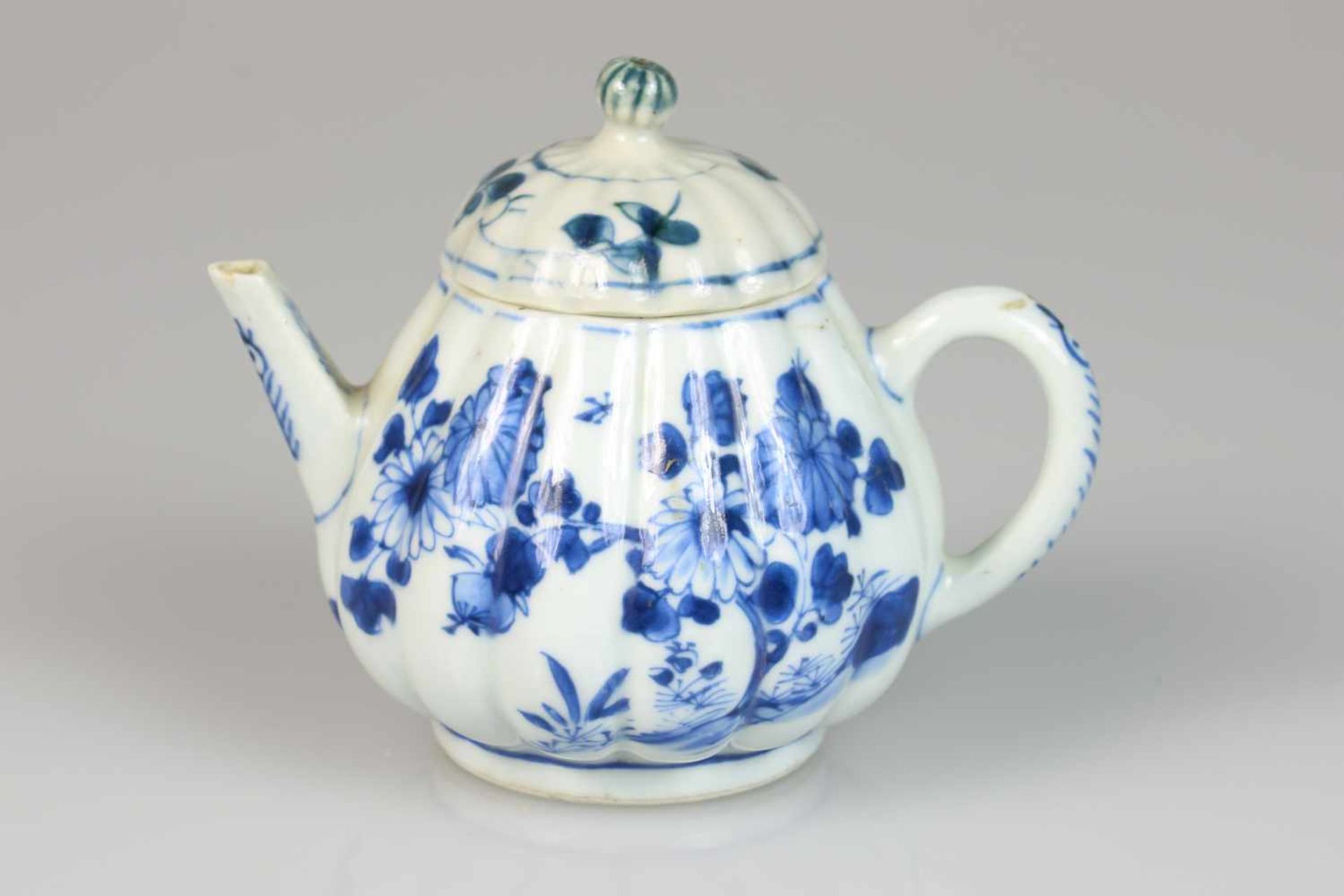 Een porseleinen gelobte theepot met floraal decor. China, 18e eeuw.Een haarlijn. Afm. 13 x 11 cm.