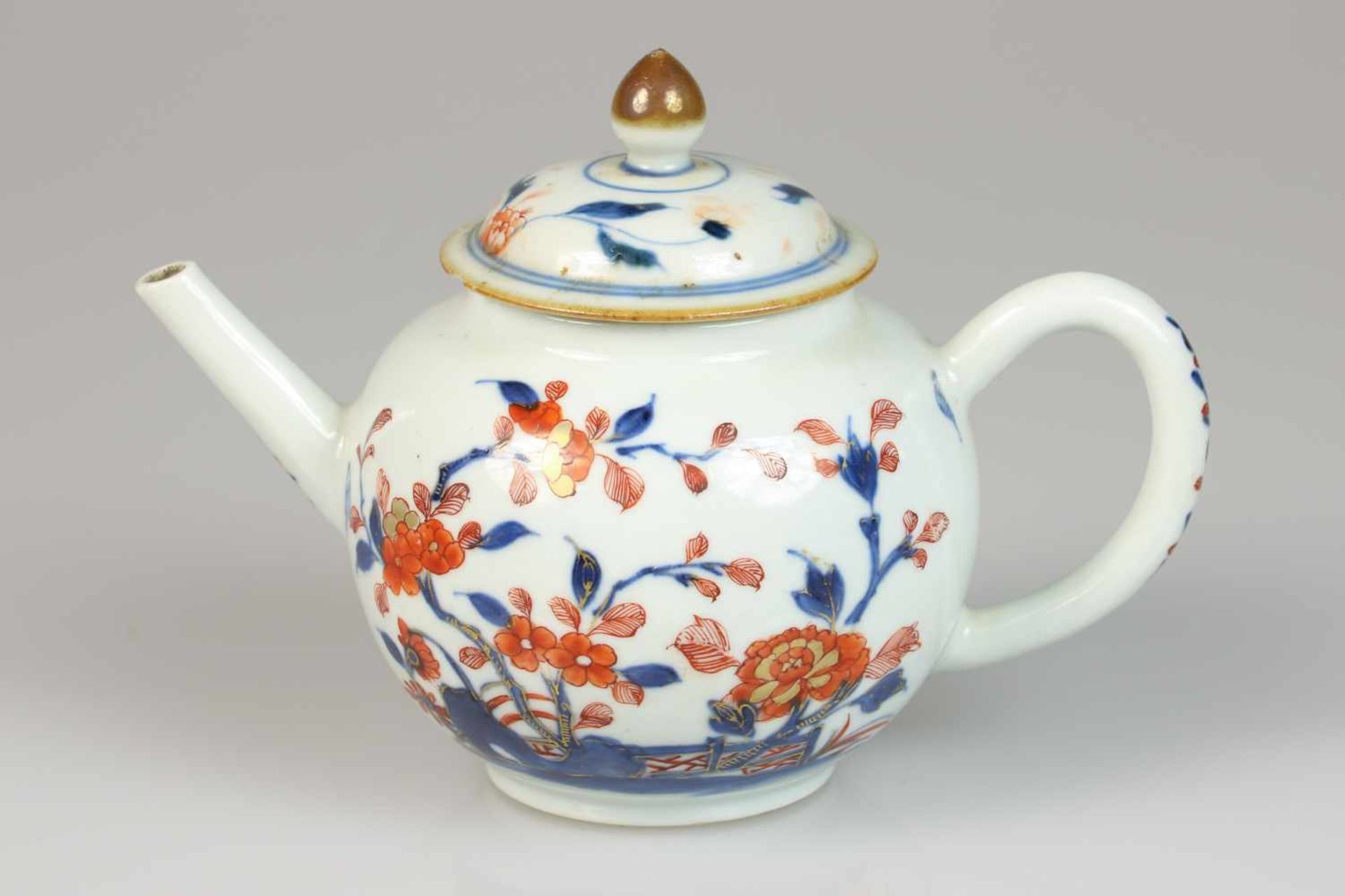 Een porseleinen theepot met Imari decor. China, 18e eeuw.Chip aan de deksel. Afm. 18 x 14 cm.