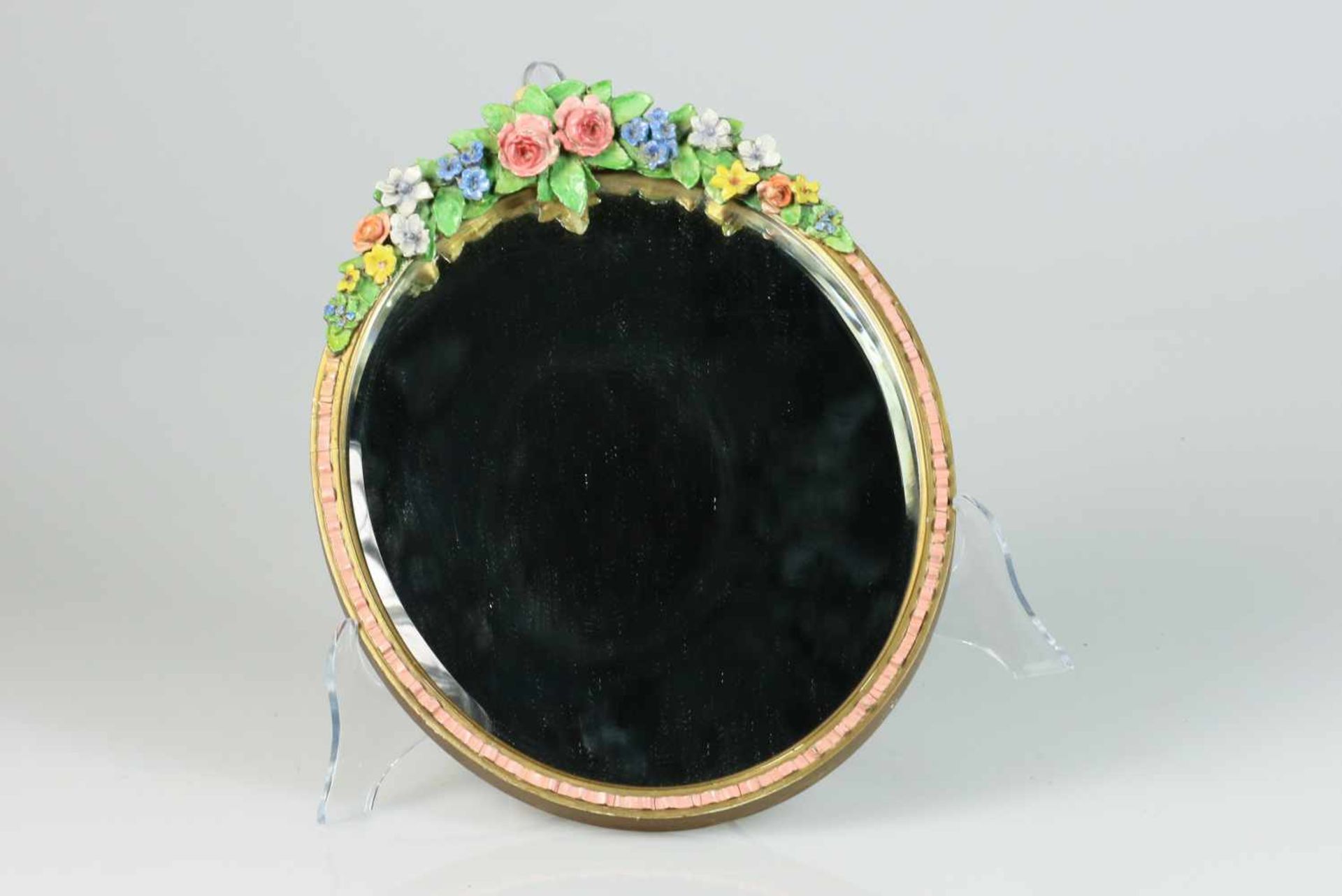 Een ovale spiegel versierd met aardewerk roosjes. Frankrijk, circa 1900.Schade aan roosjes. Afm.