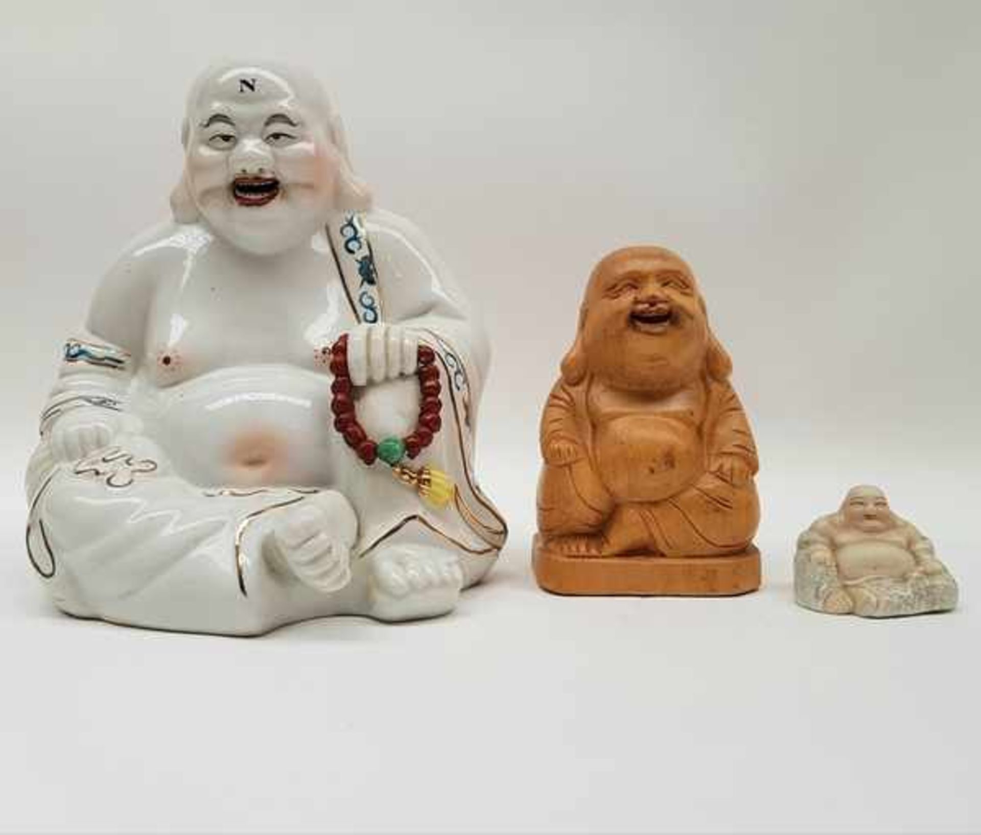 (Curiosa) Boeddha'sTwee porseleinen boeddha's en een houten boeddha. Conditie: In goede staat.