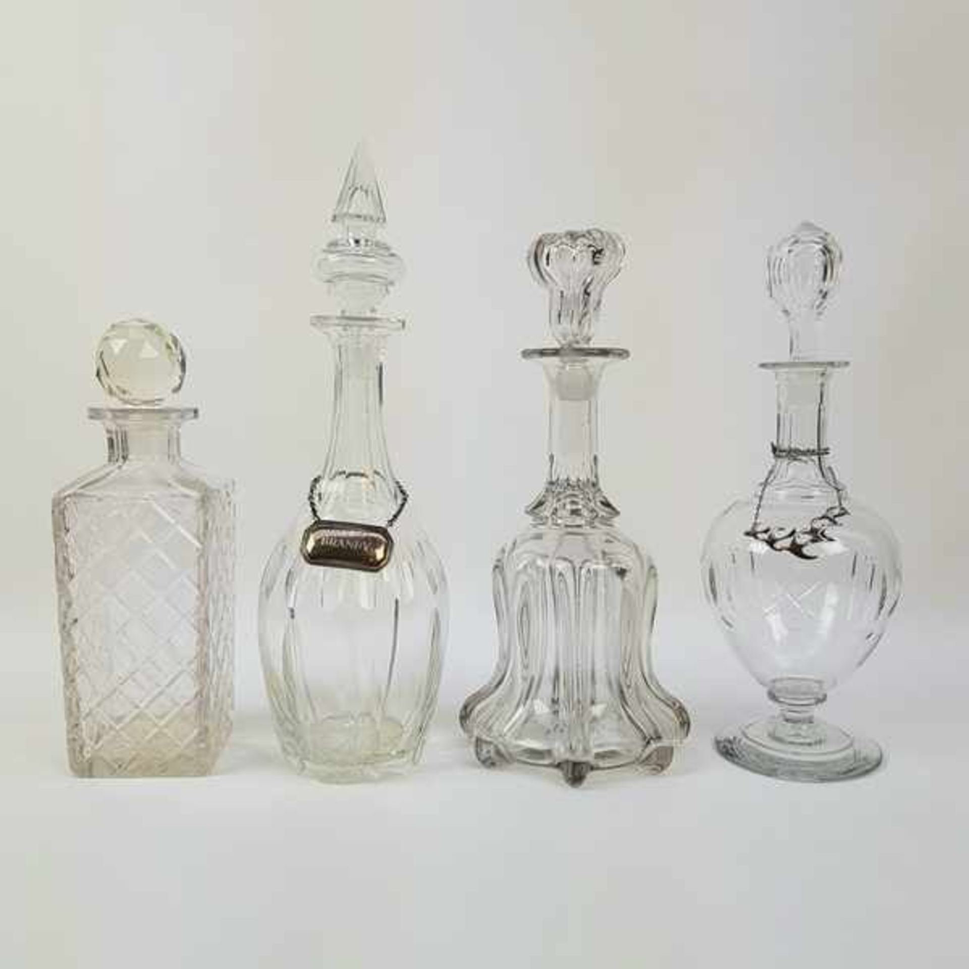 (Curiosa) Glazen karaffenVier glazen karaffen, begin 20e eeuw. Conditie: Een karaf is beschadigd.