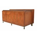 TraditionalismeAn oak sideboard with marble top, on gilt feet, the doors with brass lining and