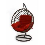 SeventiesA globular rattan hanging chair, suspended on a black metal frame with circular base,