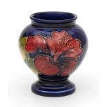 William Moorcroft (1872-1945)A miniature ceramic vase with Hibiscus pattern on a blue ground, last