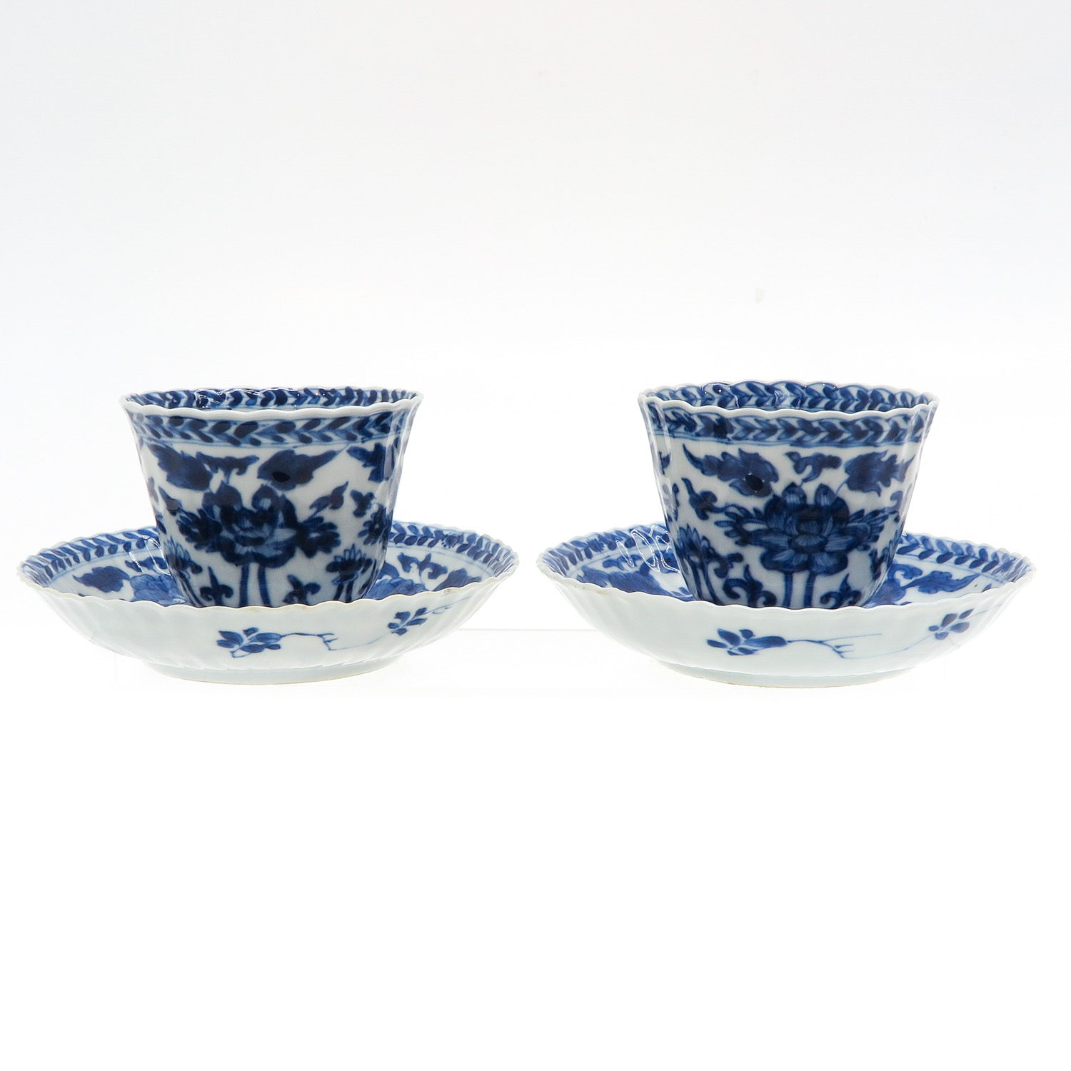 Two Blue and White Cups and Saucers