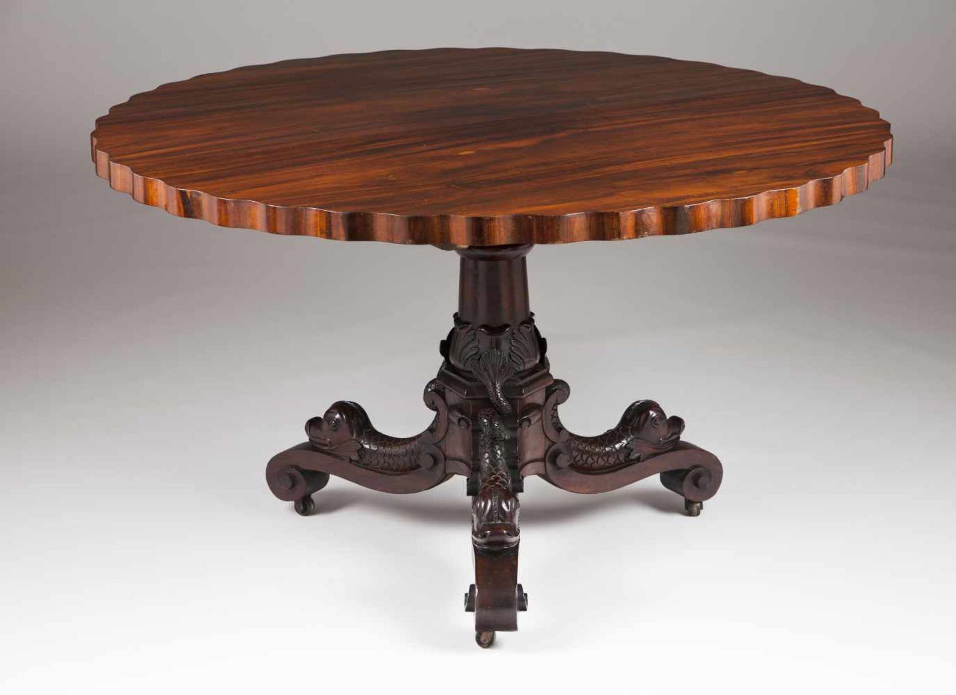 A breakfast tableRosewoodScalloped tilt-topCentral pedestal on three dolphin shaped fee