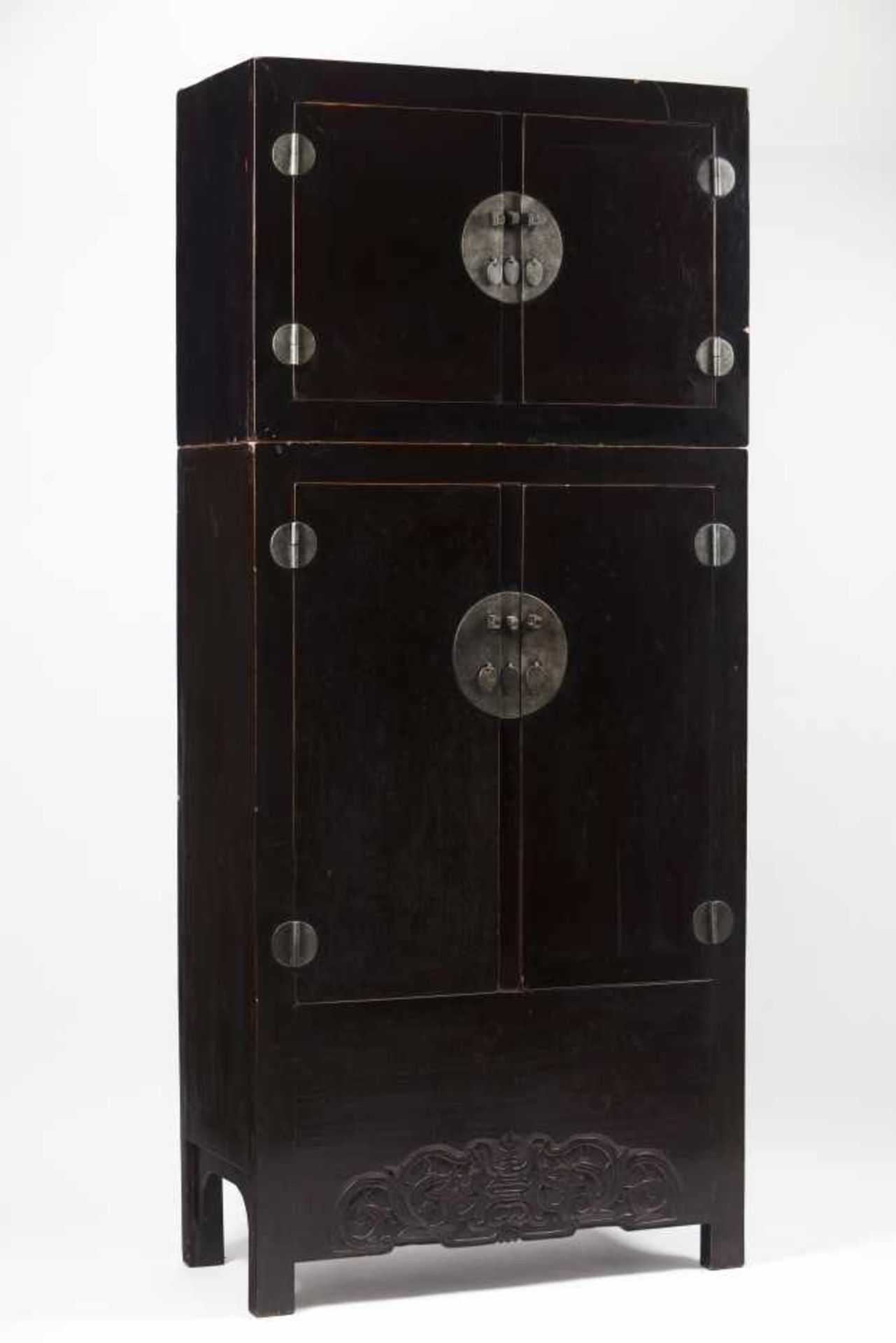 A large "Moon Face" cupboardBlack lacquered elm woodIn two sections with silvered metal har