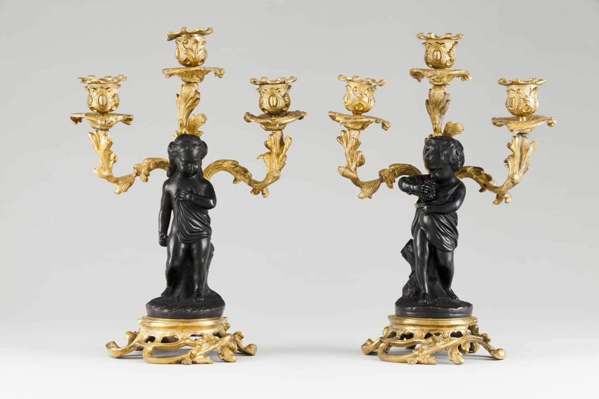 A pair of Louis XV style candelabraRaised, gilt and patinated bronzeFoliage motifs and putt