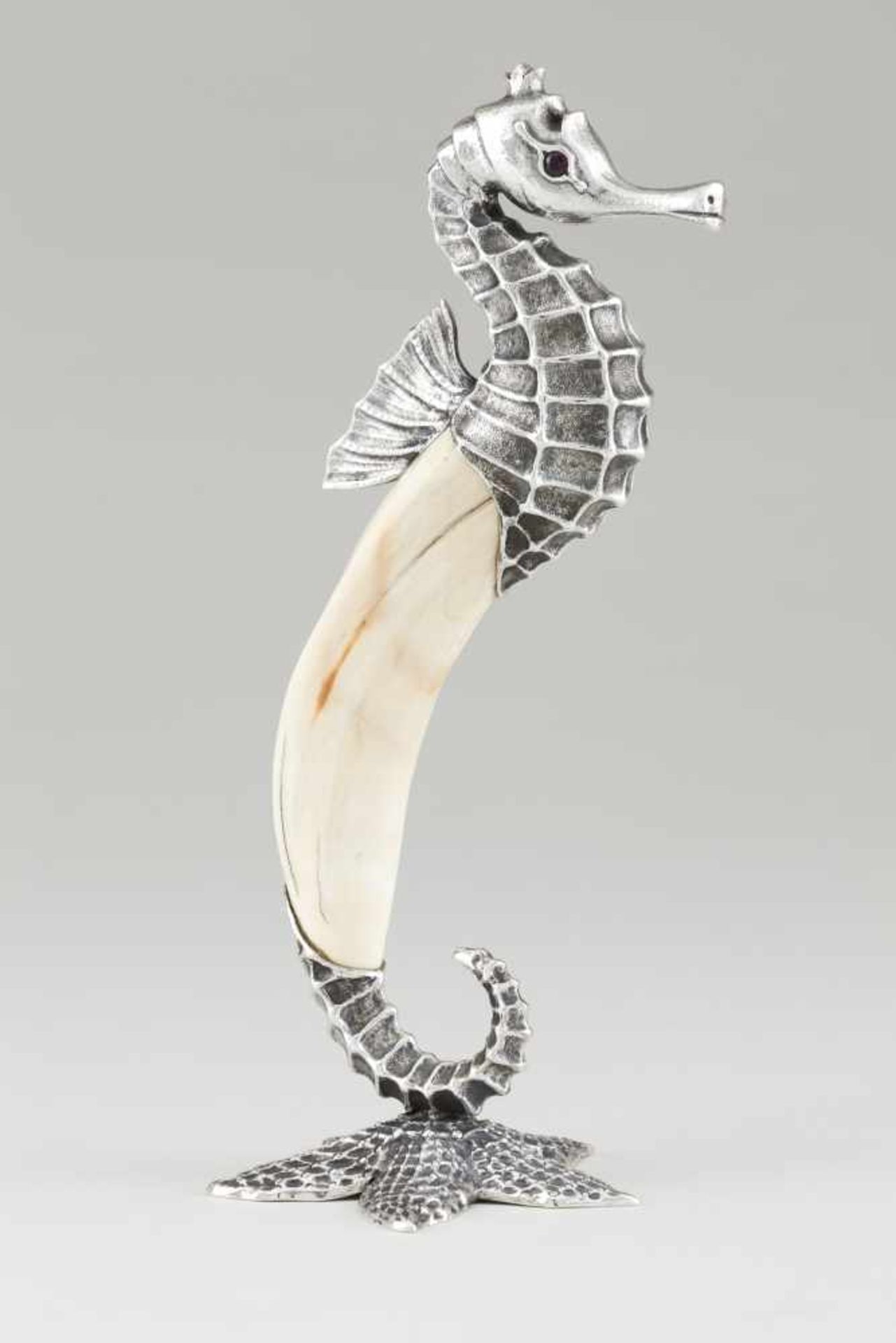 A seahorseSilverWarthog tusk with sculpted and engraved silver details, red stone eyesS