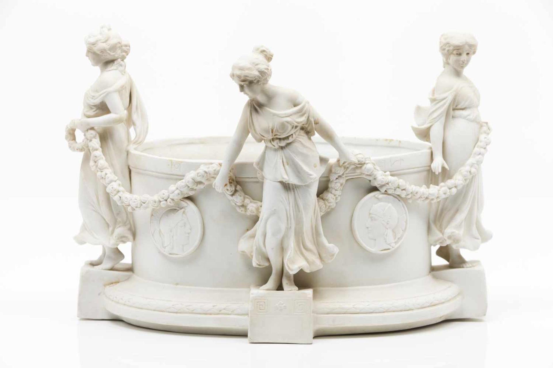 A flower bowlBiscuit porcelaindepicting the Three Graces holding garlandsMedallions wit