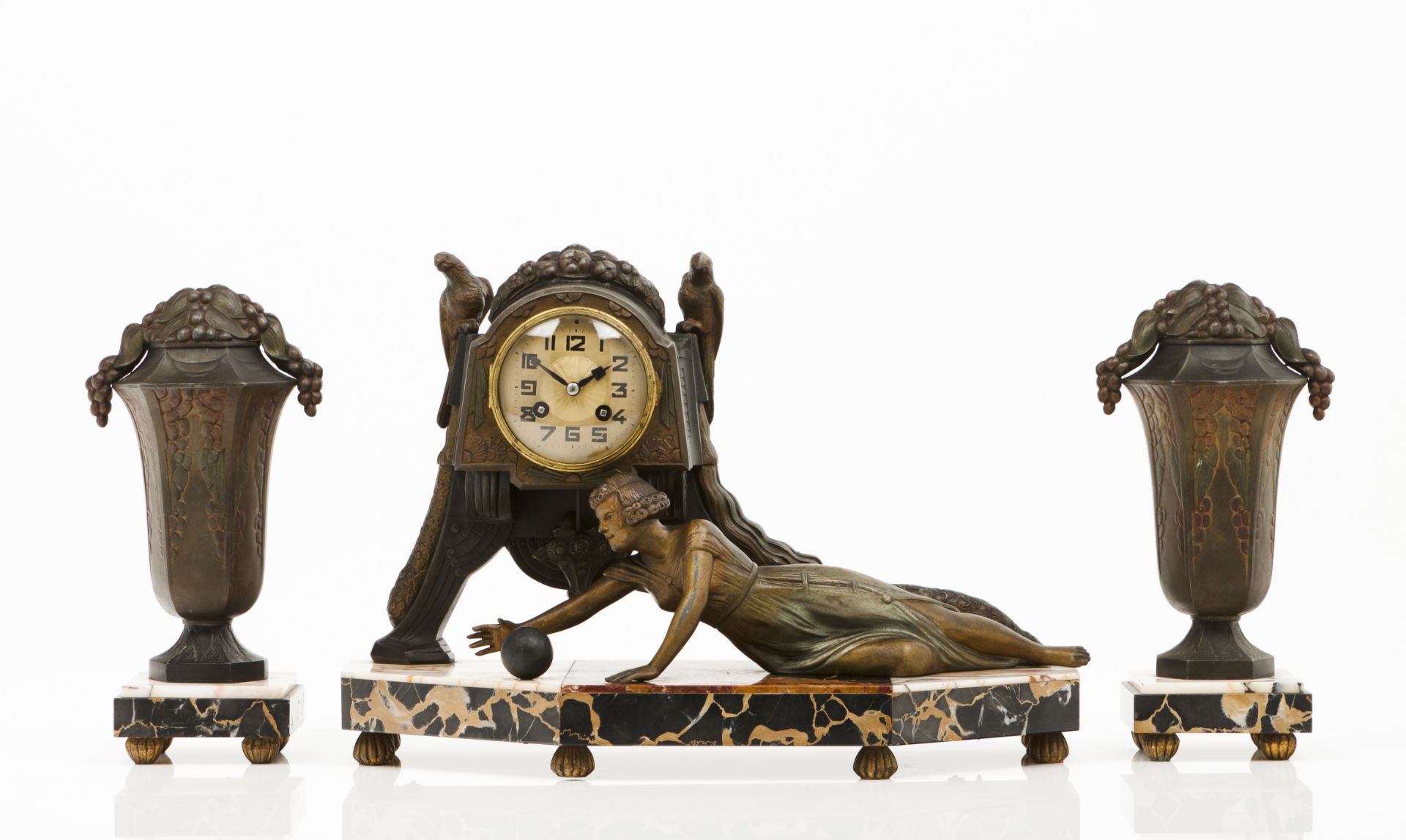 An Art Nouveau garnitureA clock and a pair of amphoraePatinated and painted metalMarble coated