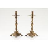 A pair of Iberian candlesticksYellow metalTriangular stand and turned shaftZoomorphic feet17th