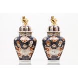 A pair of pots with coversJapanese porcelainImari decoration with flowers and animalsPolychrome