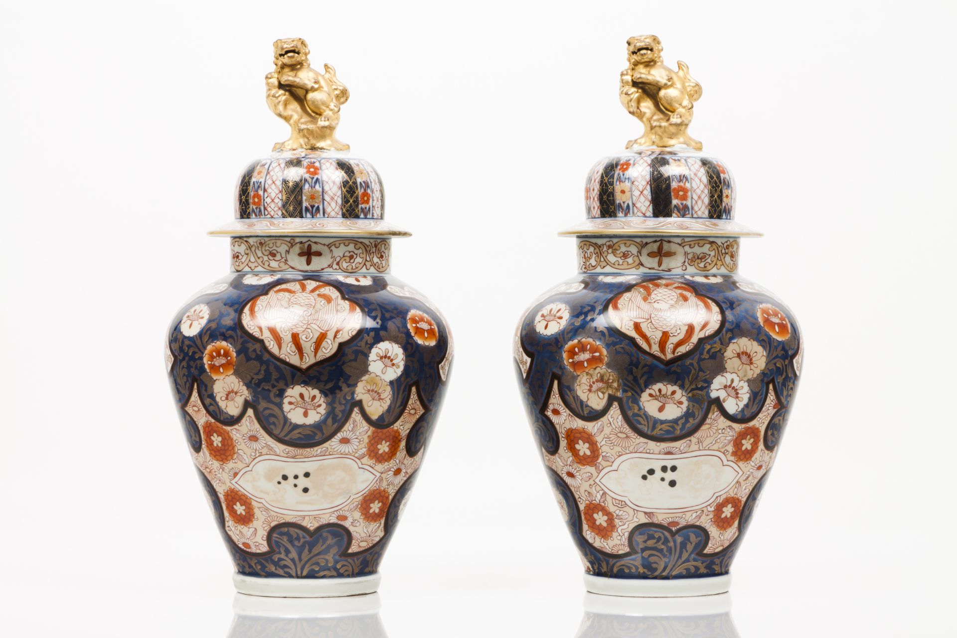 A pair of pots with coversJapanese porcelainImari decoration with flowers and animalsPolychrome