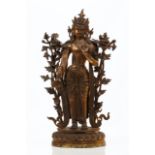 A gilt bronze figure of AvalokiteshvaraDepicting a standing figure of Avalokiteshvara encircled in