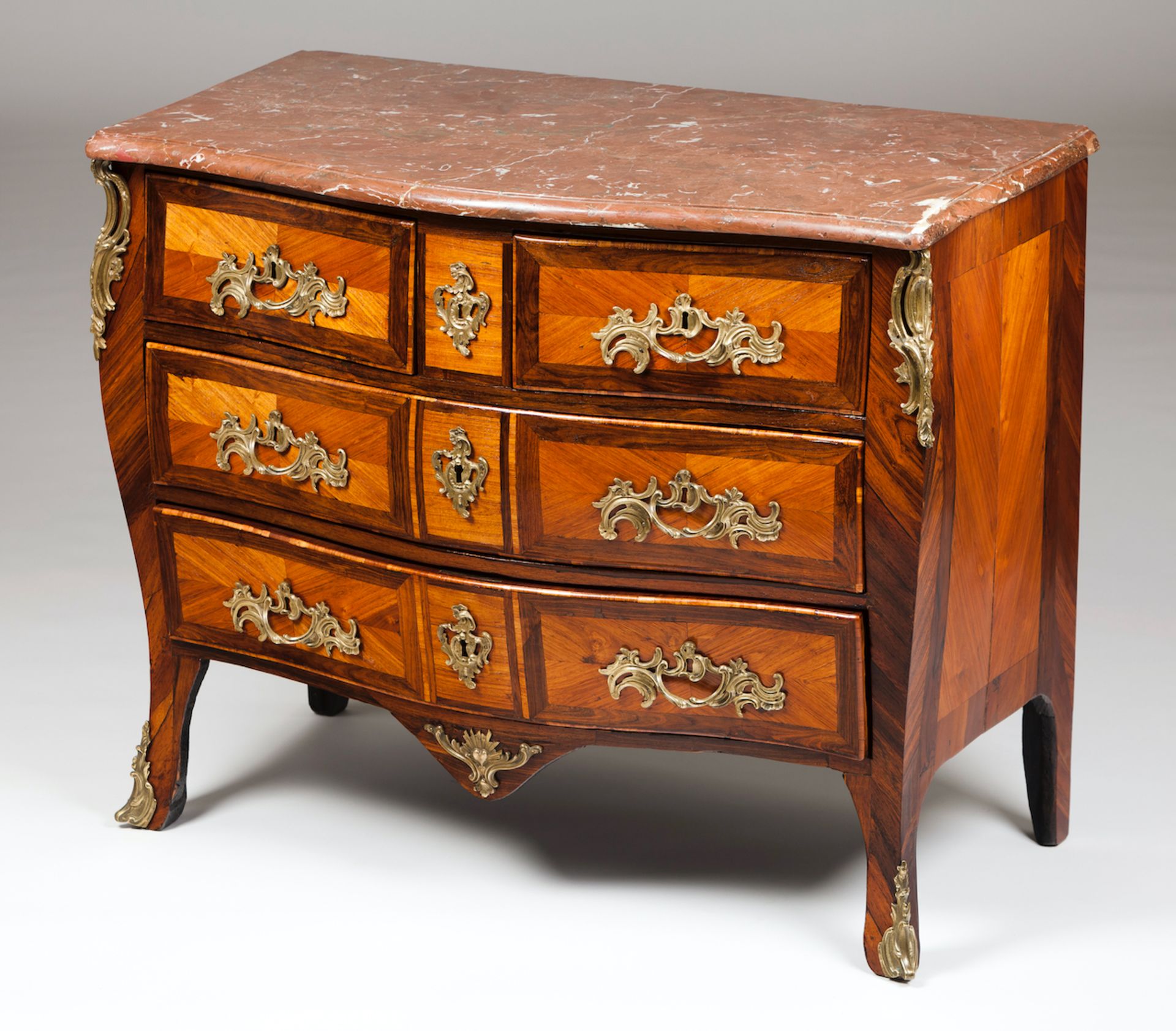 A Louis XV commodeRosewood and jacaranda marquetry workMarble top with applied raised and gilt