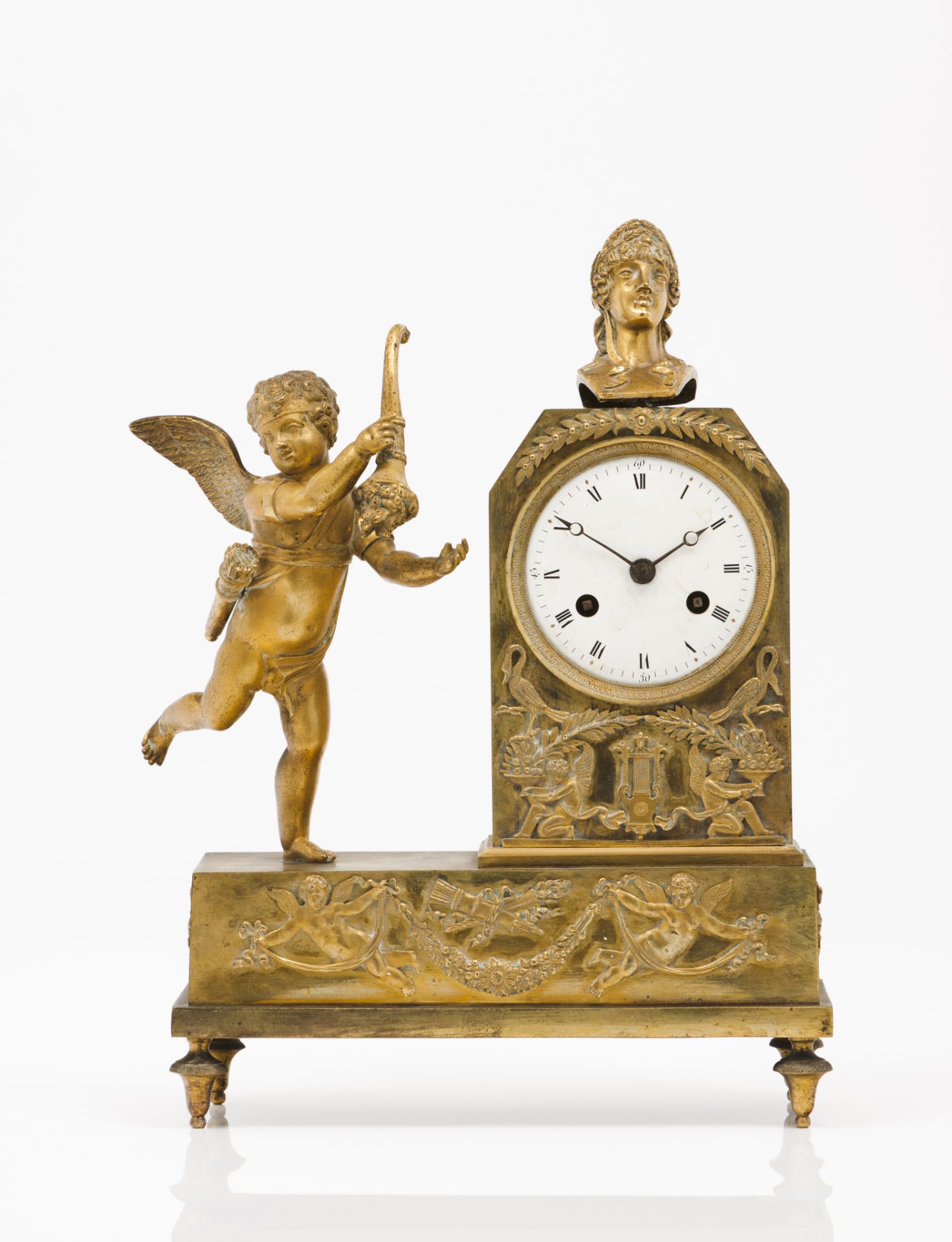 A table clockGilt bronzeDecoration of Cupid holding cornucopia, female bust and low-relief with