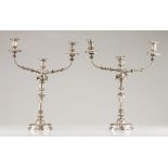 A pair of three branch candelabra by David FerreiraPortuguese silverTurned shaft of raised foliage