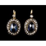 A pair of drop earringsGold and silverSet with two cabochon cut synthetic sapphires framed by 40