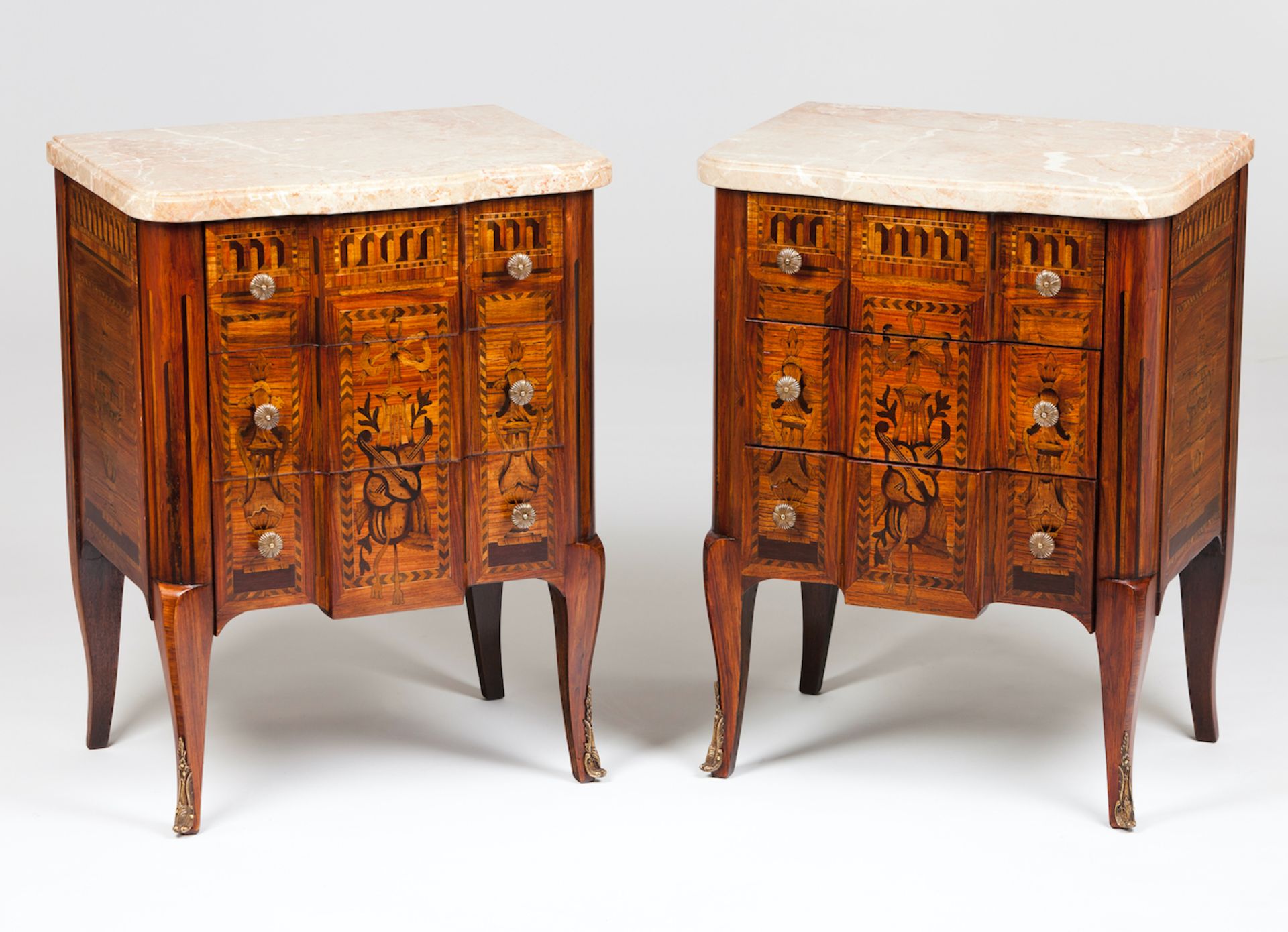 A pair of Louis XV/XVI style bedside cabinetsThornbush and mahogany marquetry decoration of