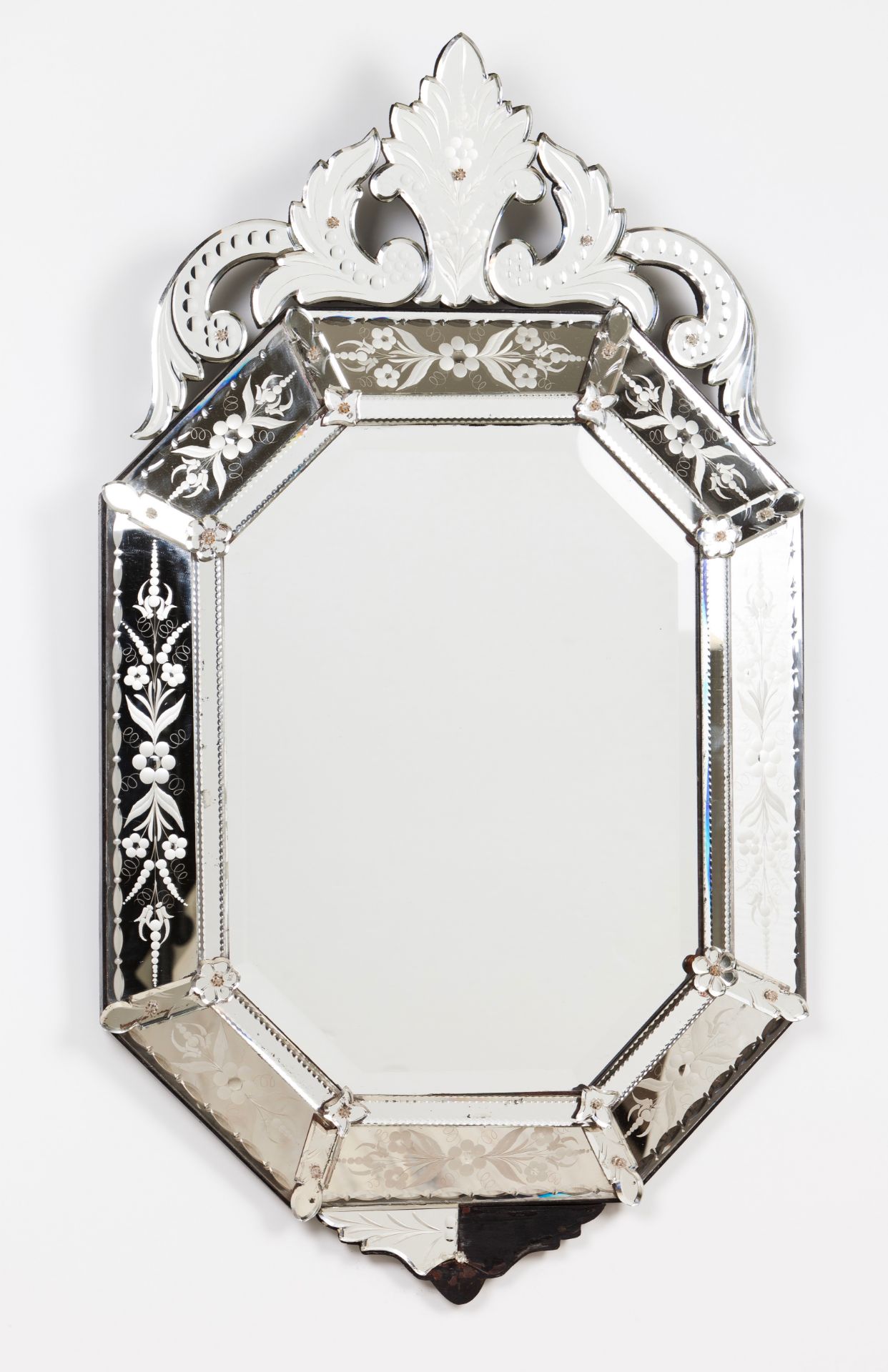 A Venetian mirrorOctagonal, with engraved decoration of floral motifs Scalloped crest and apron