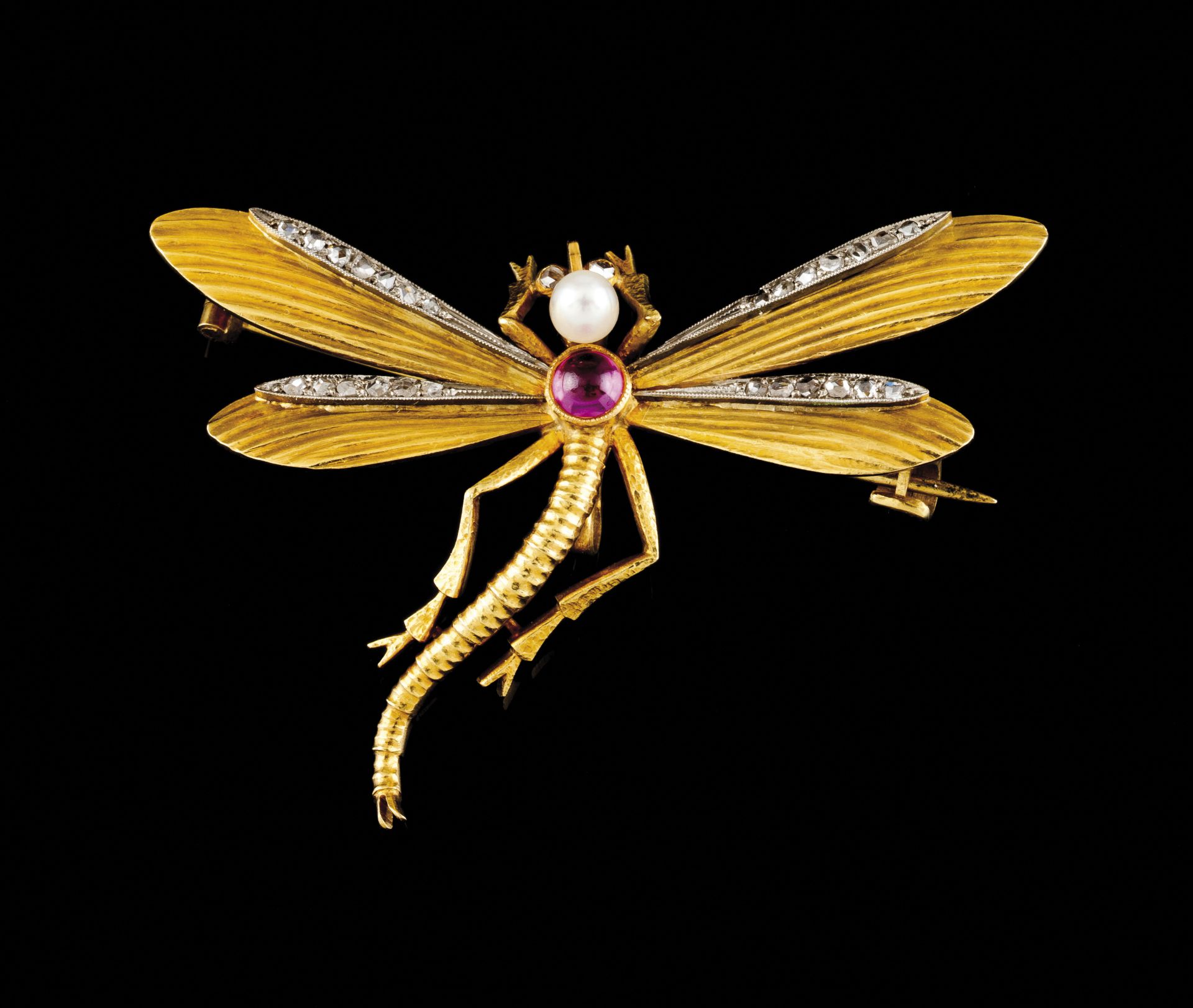 A dragonfly broochGold and platinumChiselled body set with one cabochon cut ruby and pearlWings