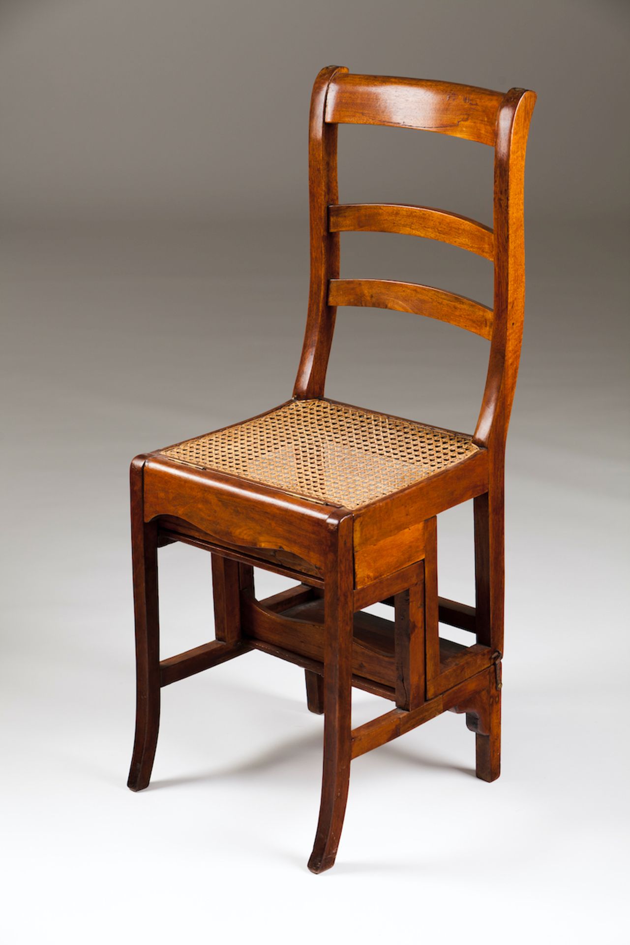 A library chair/ladderMahoganyCanned seat20th centuryHeight: 99 cm (chair)81,5 cm (ladder)