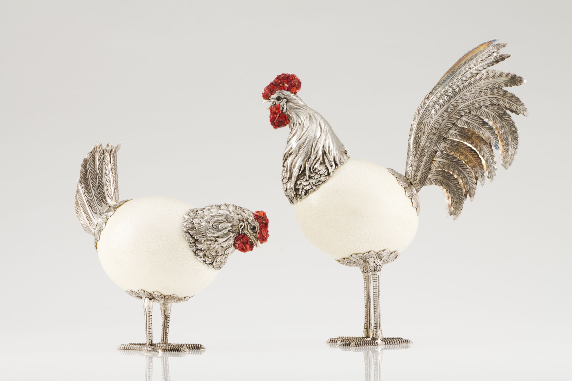 A cock and henSilver and ostrich eggCarved, scalloped and chiselled sculpture with applied red