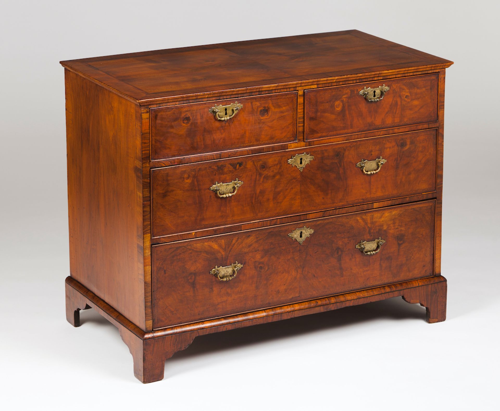 An English chest of drawersSolid and veneered burr walnutTwo short and two long drawersYellow