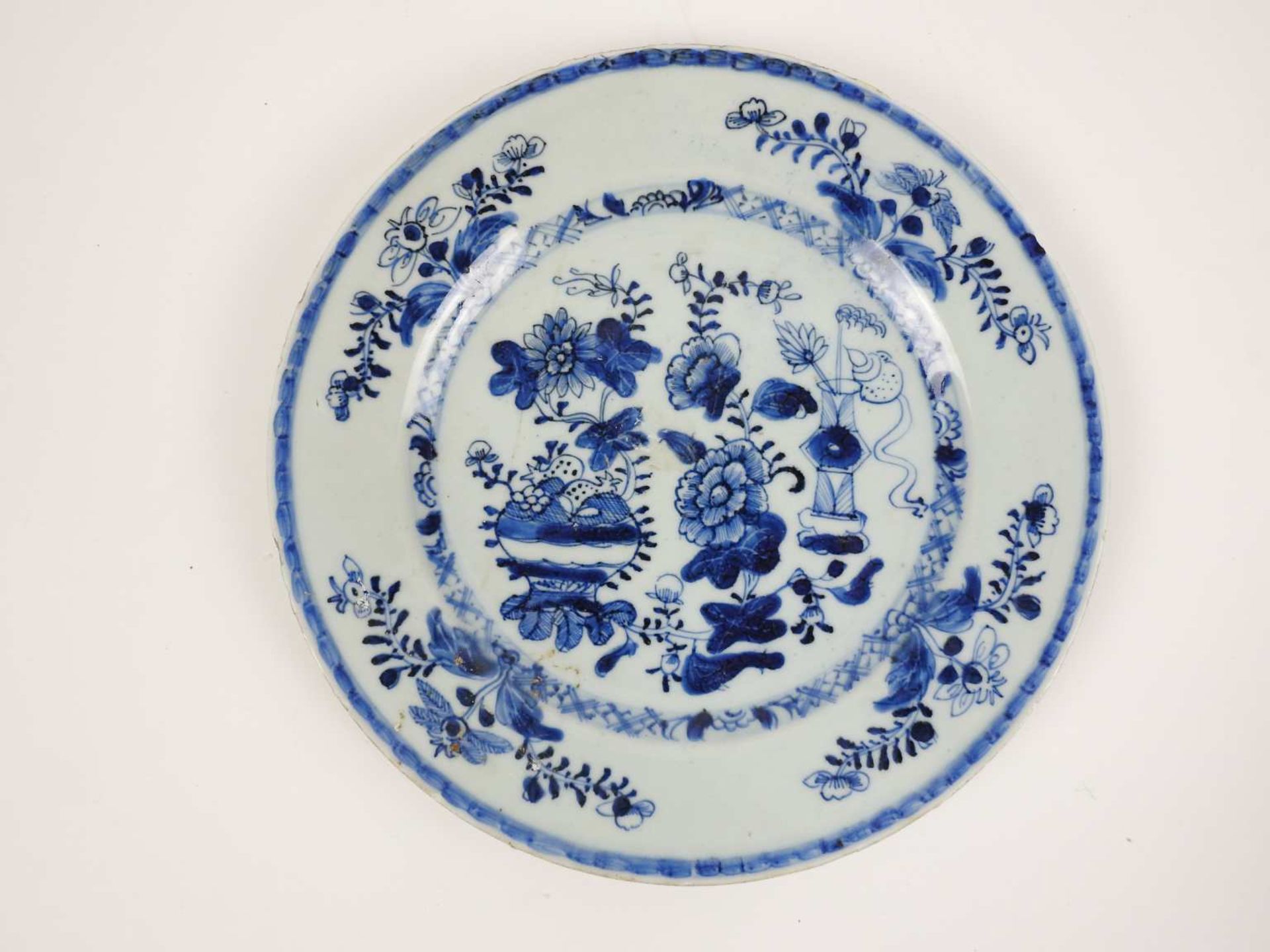 ChineAssiette en porcelaine émaillée blanche et bleue à décor floralDiam 23 cmAccidents <br