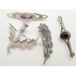 Four white metal brooches,