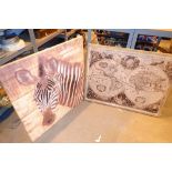 Two paintings one of a zebra on canvas one of the world on hessian