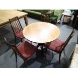 Circular teak dining table on pedestal base with four upholstered dining chairs