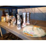 Three Continental figurines, a pair of ceramic candlesticks and a Myotts hand painted glass panel