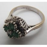 A contemporary 18ct white gold emerald and diamond cluster ring, 5.5g, size M