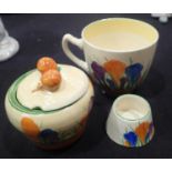 Large Clarice Cliff teacup and small pot in the Spring Crocus pattern, with a lidded preserve pot