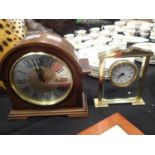 Two modern clocks, one wood effect and one brass and perspex