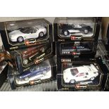 Seven boxed Burago diecast model cars. Boxes in poor condition, vehicles undamaged. P&P to