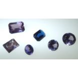 Loose gemstones: five mixed sapphires and a blue glass emerald cut stone 12.5 x 10 mm, 3.8g (