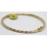 Ladies 9ct gold oval twist hinged bangle. P&P Group 1 (£14+VAT for the first lot and £1+VAT for