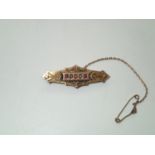 Antique 9ct gold mourning bar brooch set with red stones and seed pearls, the reverse having a small