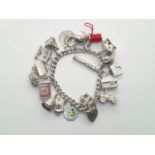 Heavy vintage silver charm bracelet with 19 charms with many Nuvo examples, including rare cotton