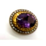 Large oval amethyst set in a presumed 9ct gold mount with screw back and surrounded by seed