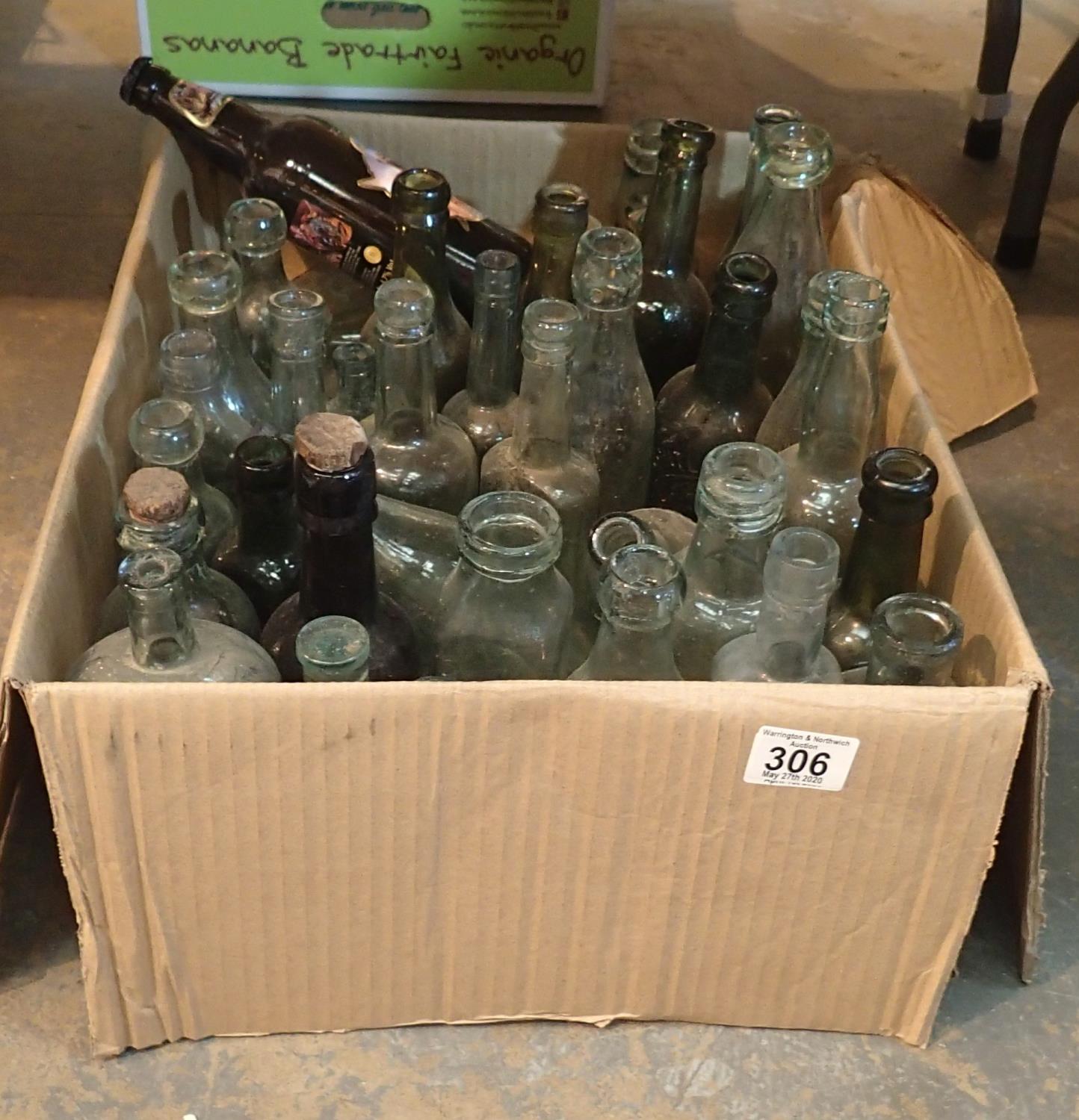 Box of predominantly green glass antique bottles including medicine and soda examples. This lot is