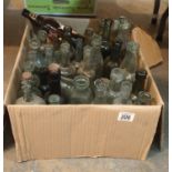 Box of predominantly green glass antique bottles including medicine and soda examples. This lot is