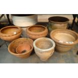 Seven earthenware garden pots, two matching with stands, two large white pots and other examples.