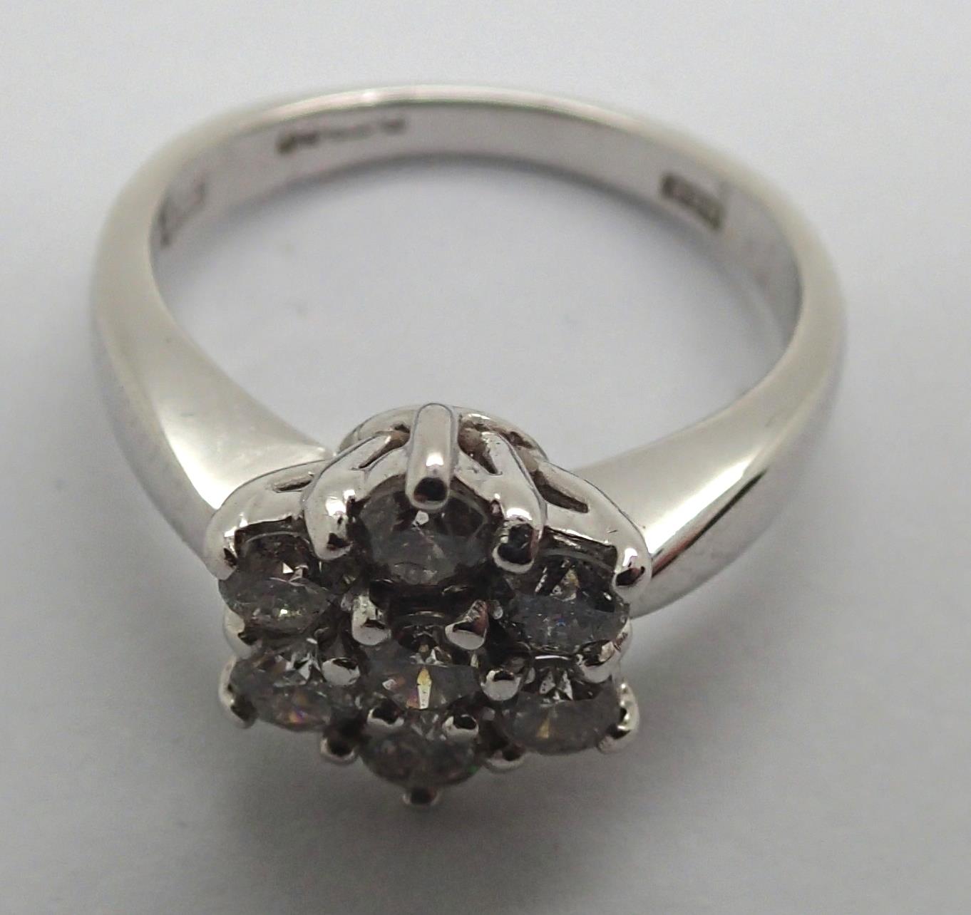 An 18ct white gold diamond flower head cluster ring totaling .75cts 4.9g, size K